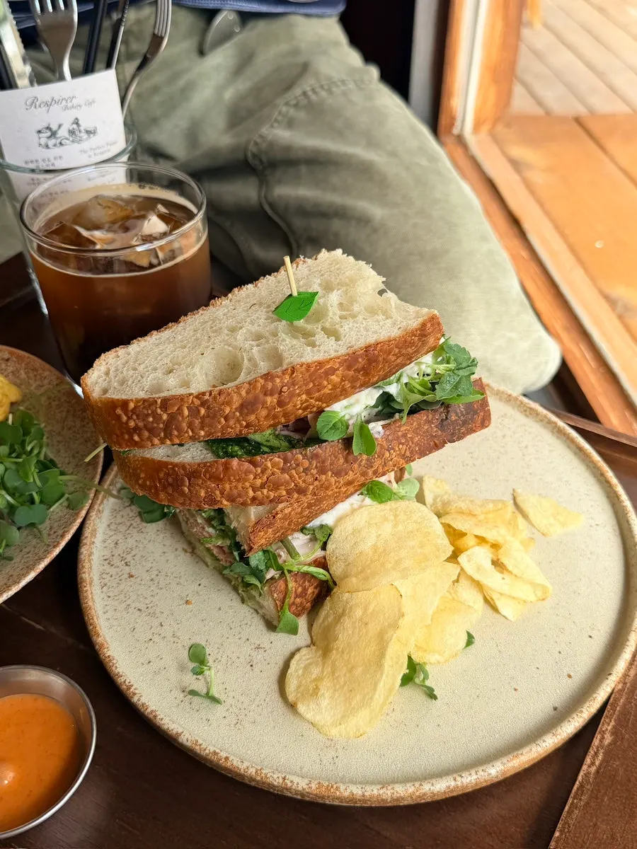 Basil jambon sandwich served with potato chips