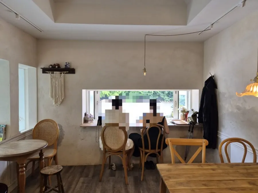 Second-floor seating with a small window at Respire Bakery Cafe Seochon
