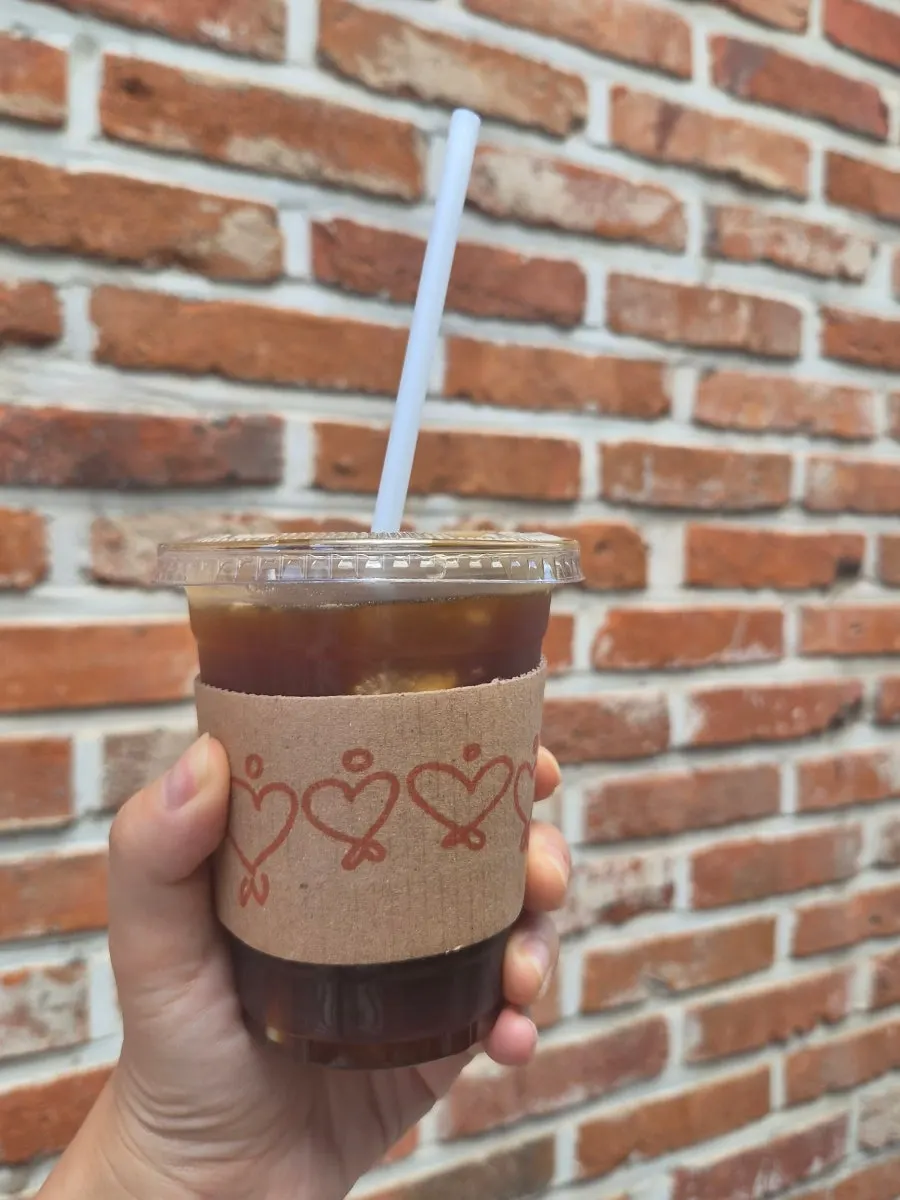 A takeout iced americano with a Seochon alley in the background