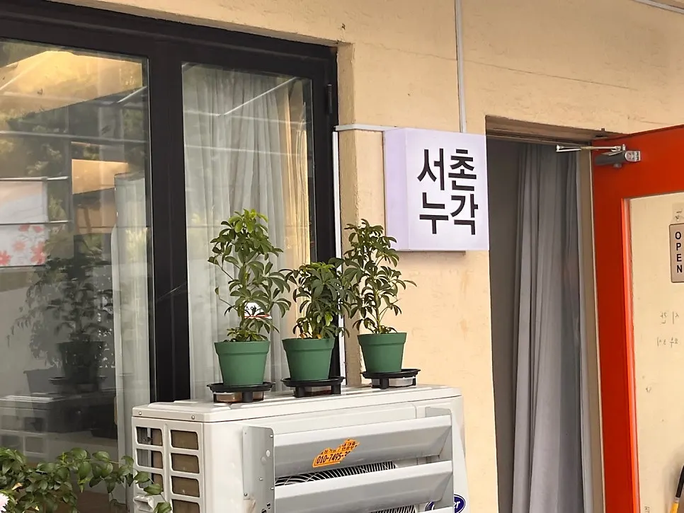 서촌누각 입구 화분과 레드 도어