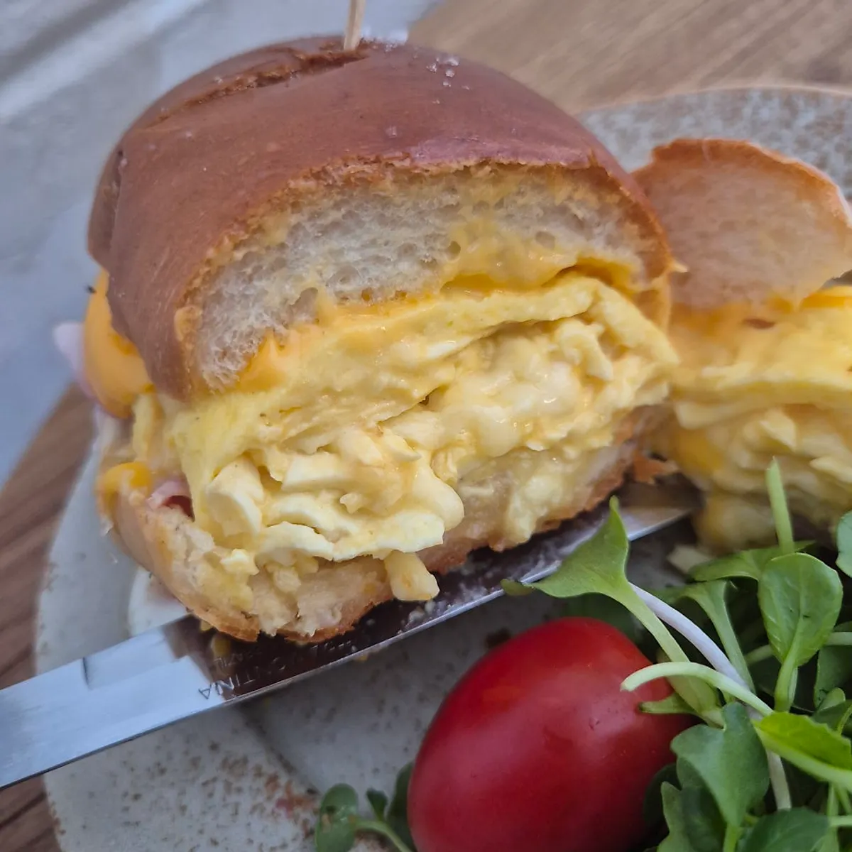 A bite taken out of the omelette sandwich