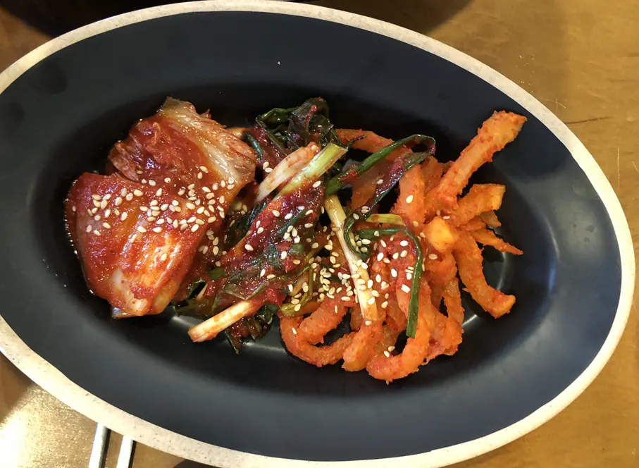 A plate of bossam kimchi and radish kimchi from the self-serve bar