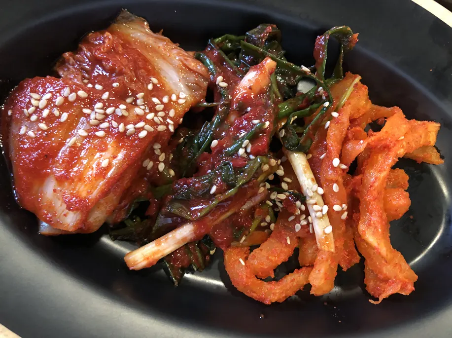 A bowl of richly seasoned three-kind bossam kimchi