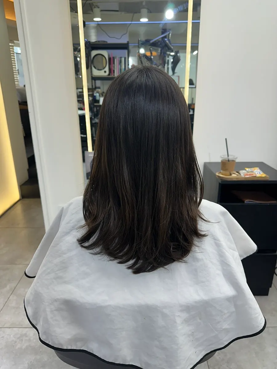 Finished medium-length layered C-curl perm, front view