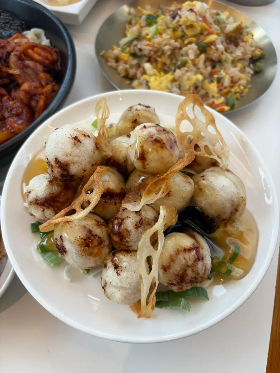 A plate of mokhwasolm tangsuyuk topped with fried lotus root