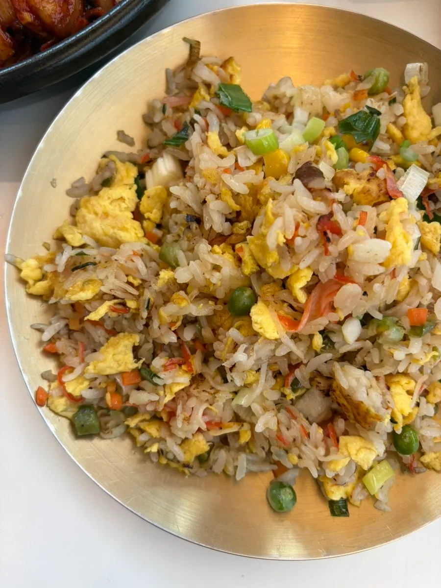 Fried rice filled with sweet peas, crab sticks, and egg
