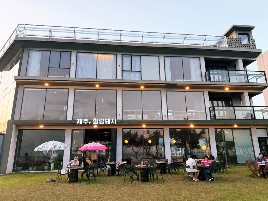 Restaurant exterior with the Jeju sea and a lawn garden
