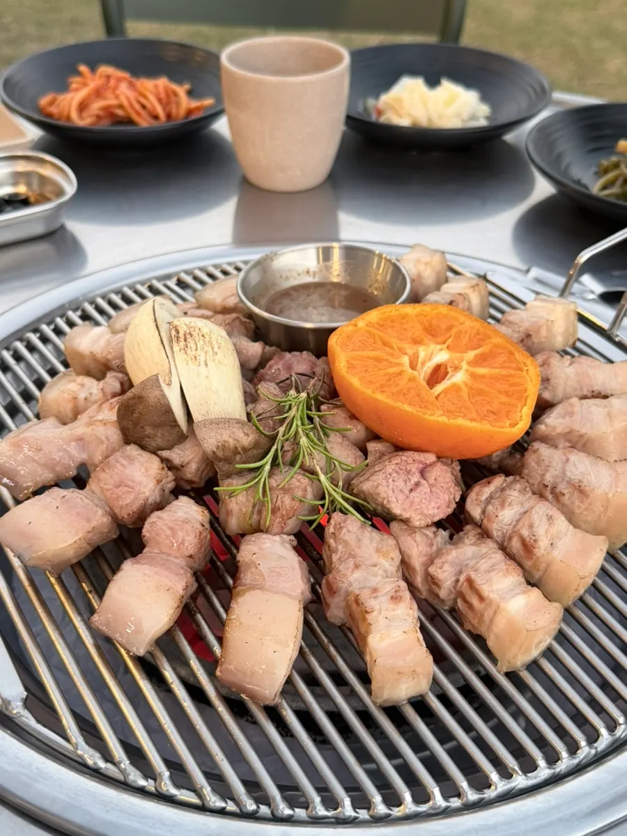 Thick black pork cooking over charcoal