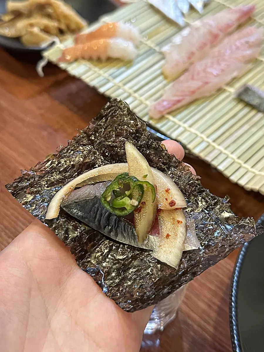 Mackerel sashimi wrapped in seaweed with pickled onion