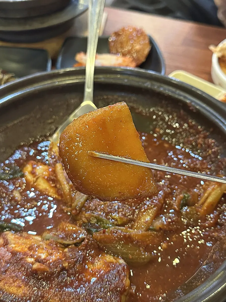 A spoonful of hot pot rice with fluffy potato