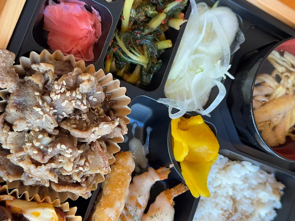 Lunch box lineup with fried shrimp and side dishes