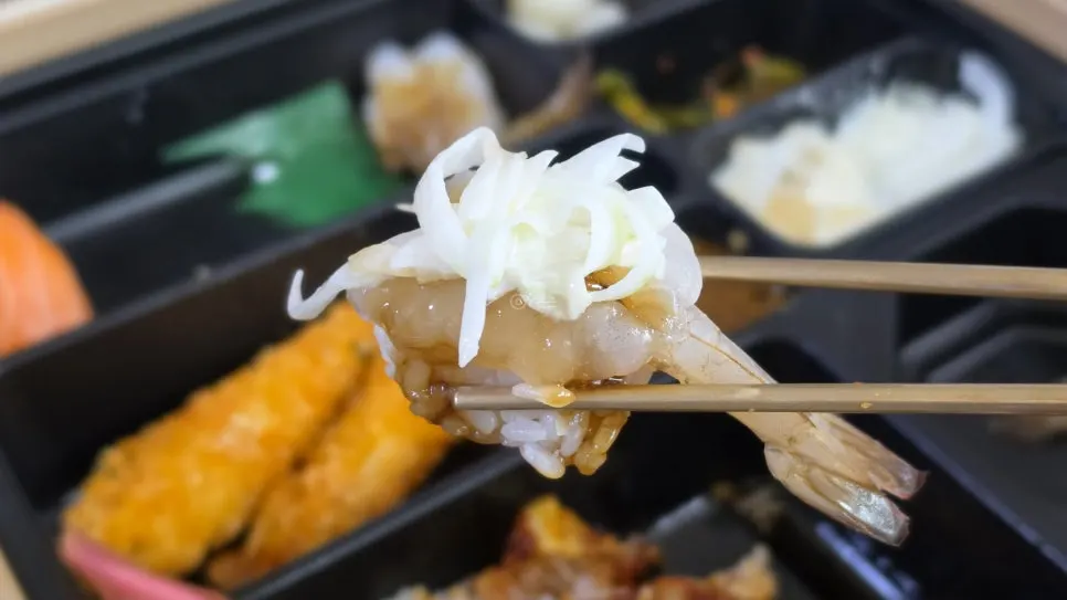 Salmon sushi held with chopsticks