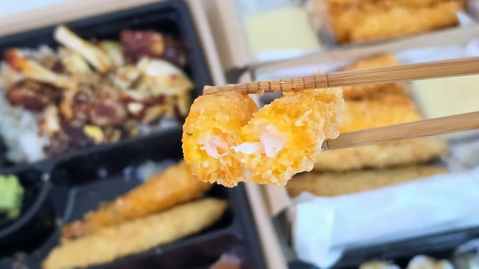 Cross-section of fish tempura dipped in sauce