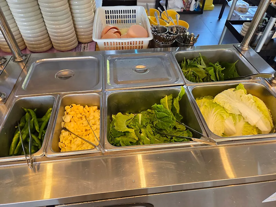Self-serve bar section with wrap vegetables, green peppers, and whole garlic