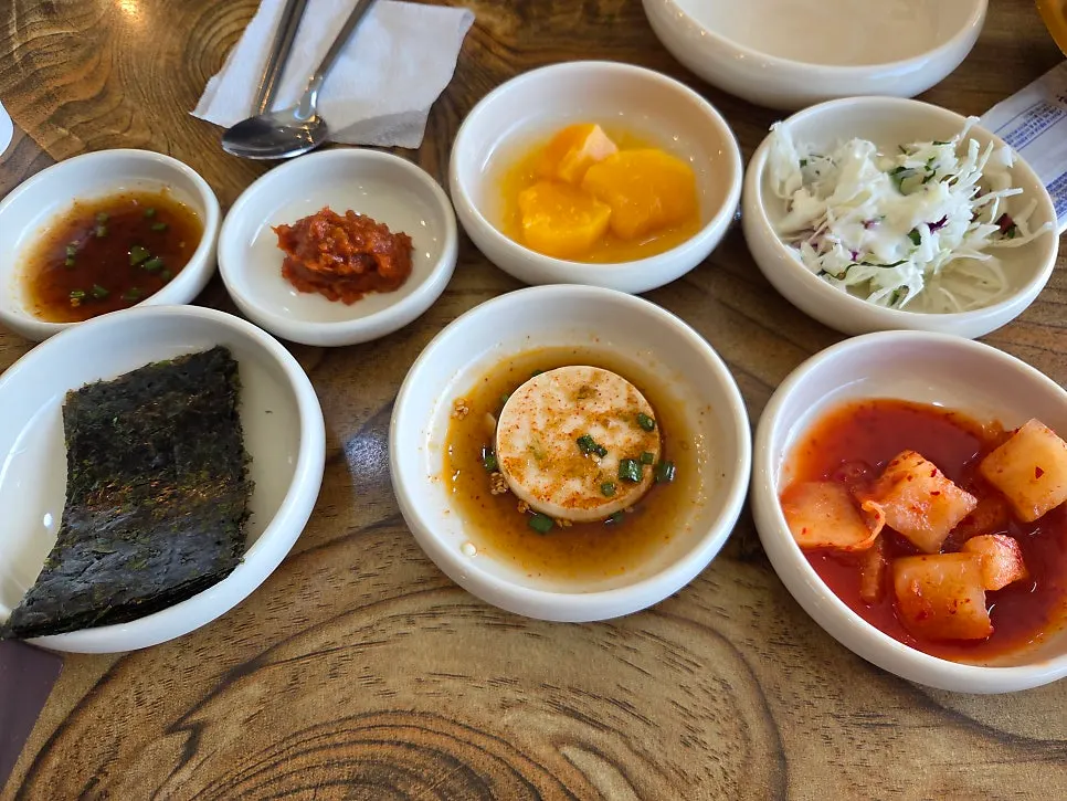 Basic side dishes on round plates including seaweed and tofu pickles