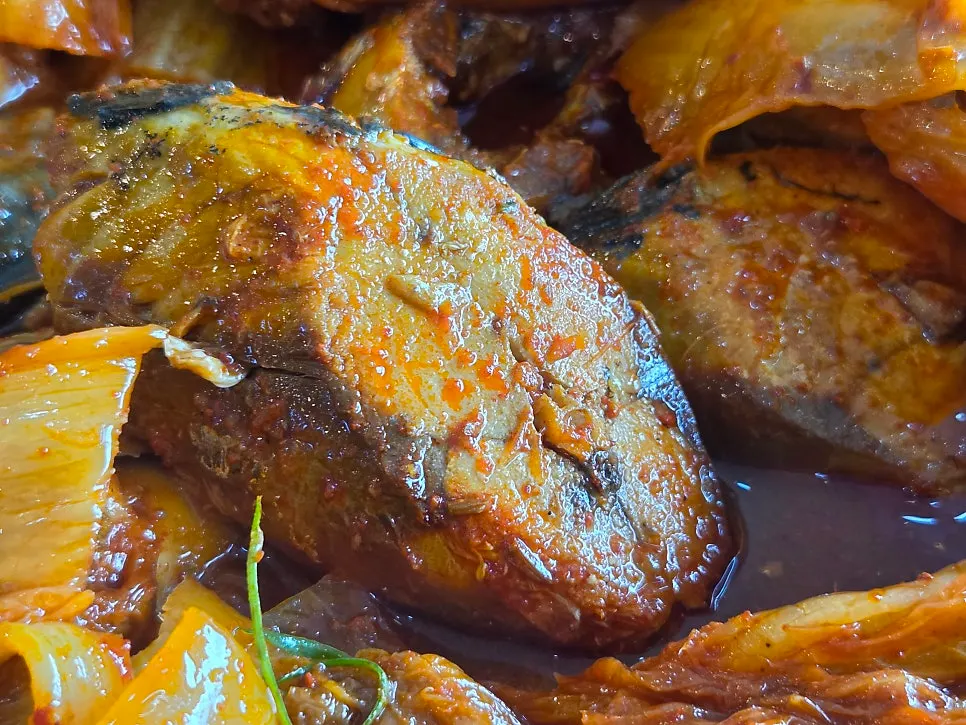 Large pieces of mackerel revealed beneath aged kimchi