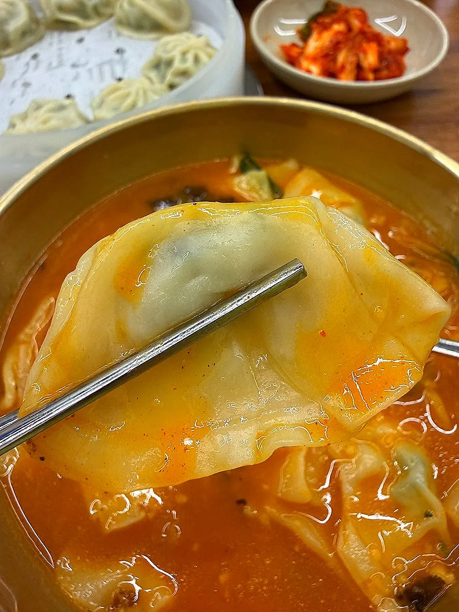 Lifting a piece of sujebi out of the broth
