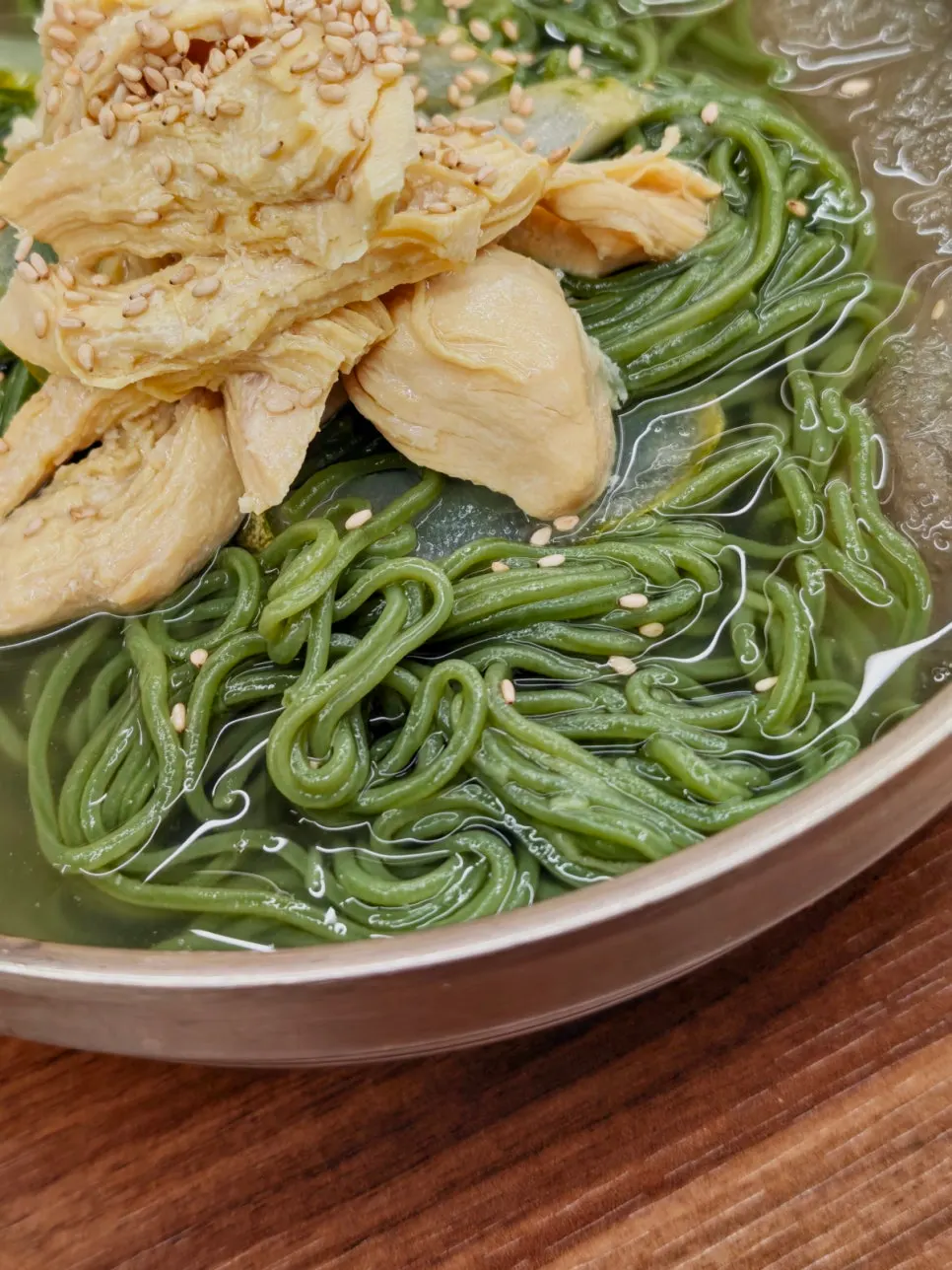 Chojegooksu with chlorella green noodles and chicken topping
