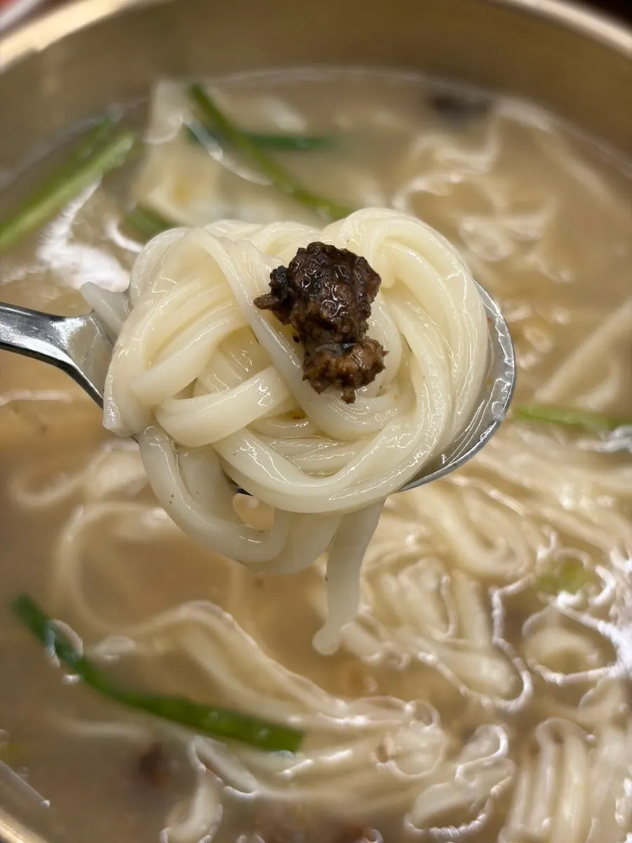 Noodles and dumplings lifted from the kalguksu bowl