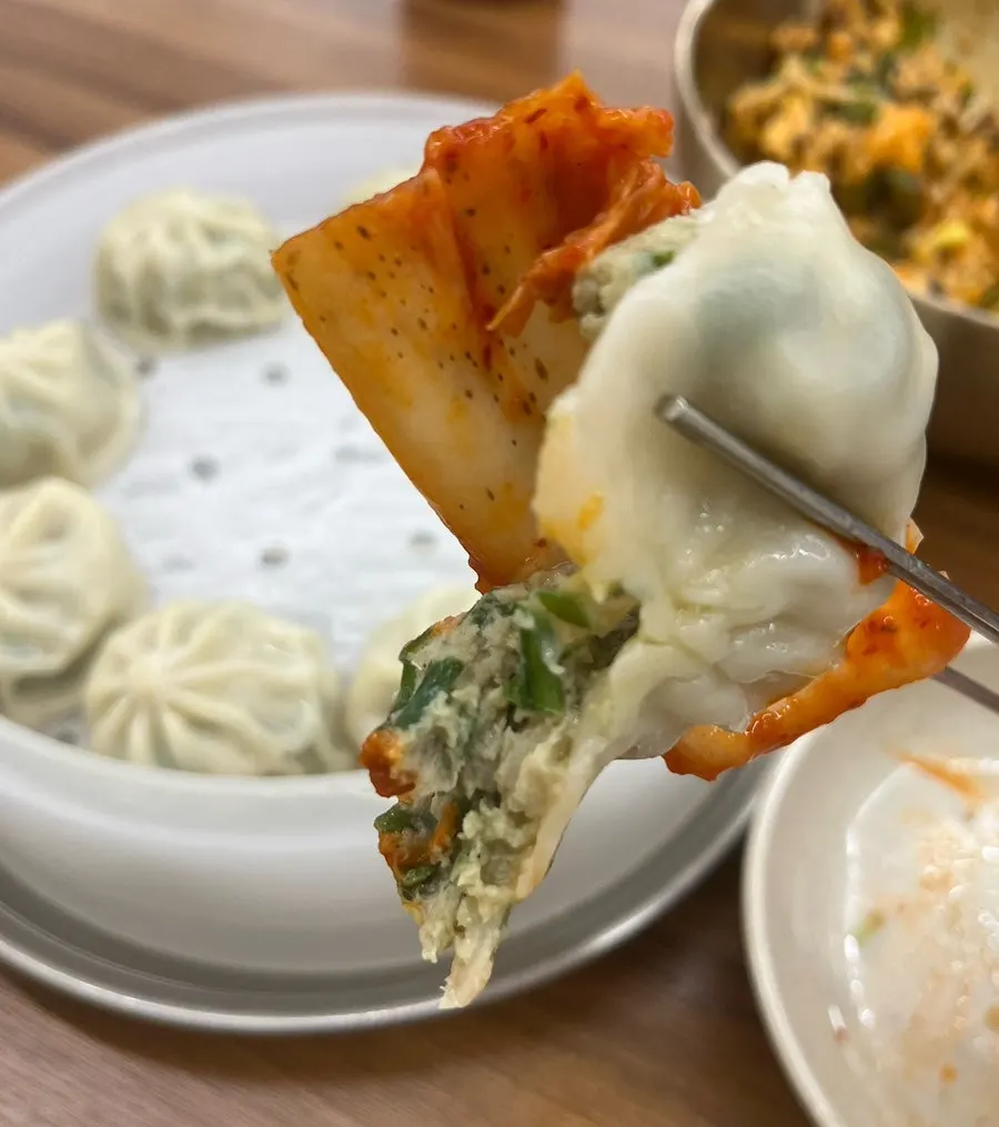 Combinación de kalguksu, gyoza dumplings y bibimbap servidos en la mesa