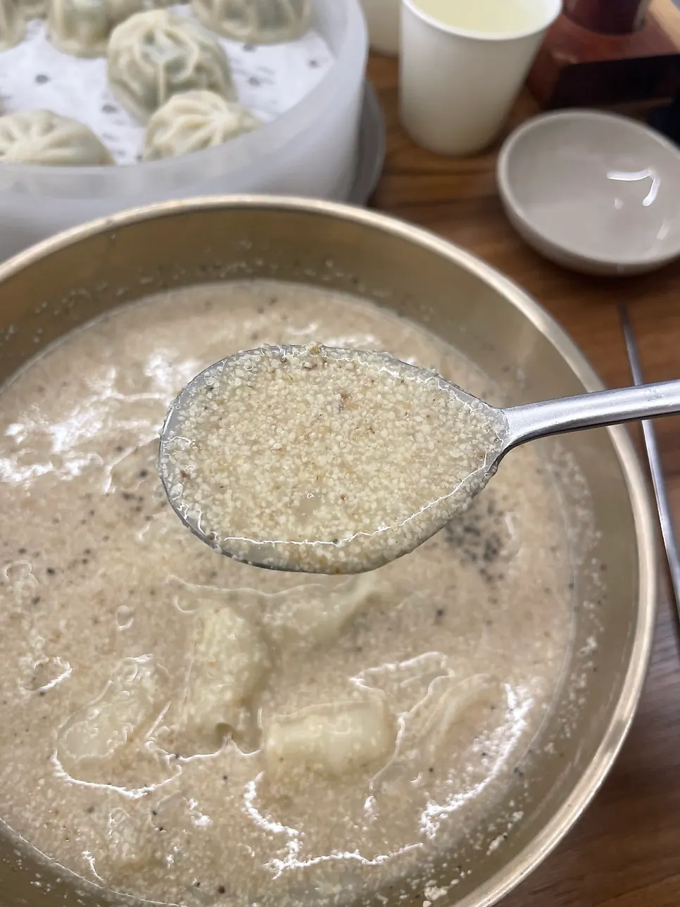 A spoonful of perilla sujebi lifted from the bowl