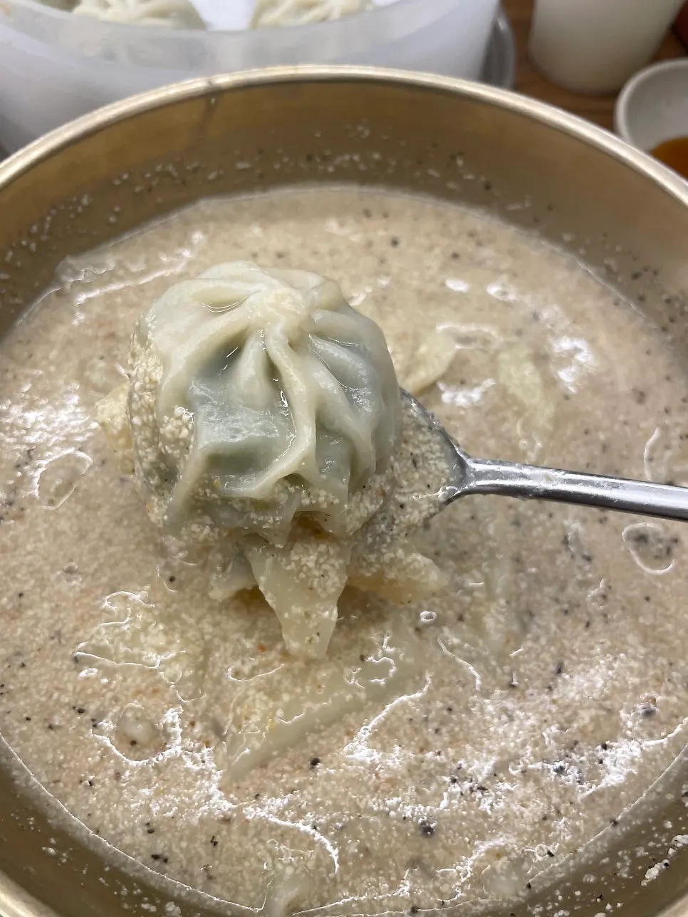 A bowl of perilla sujebi being served out
