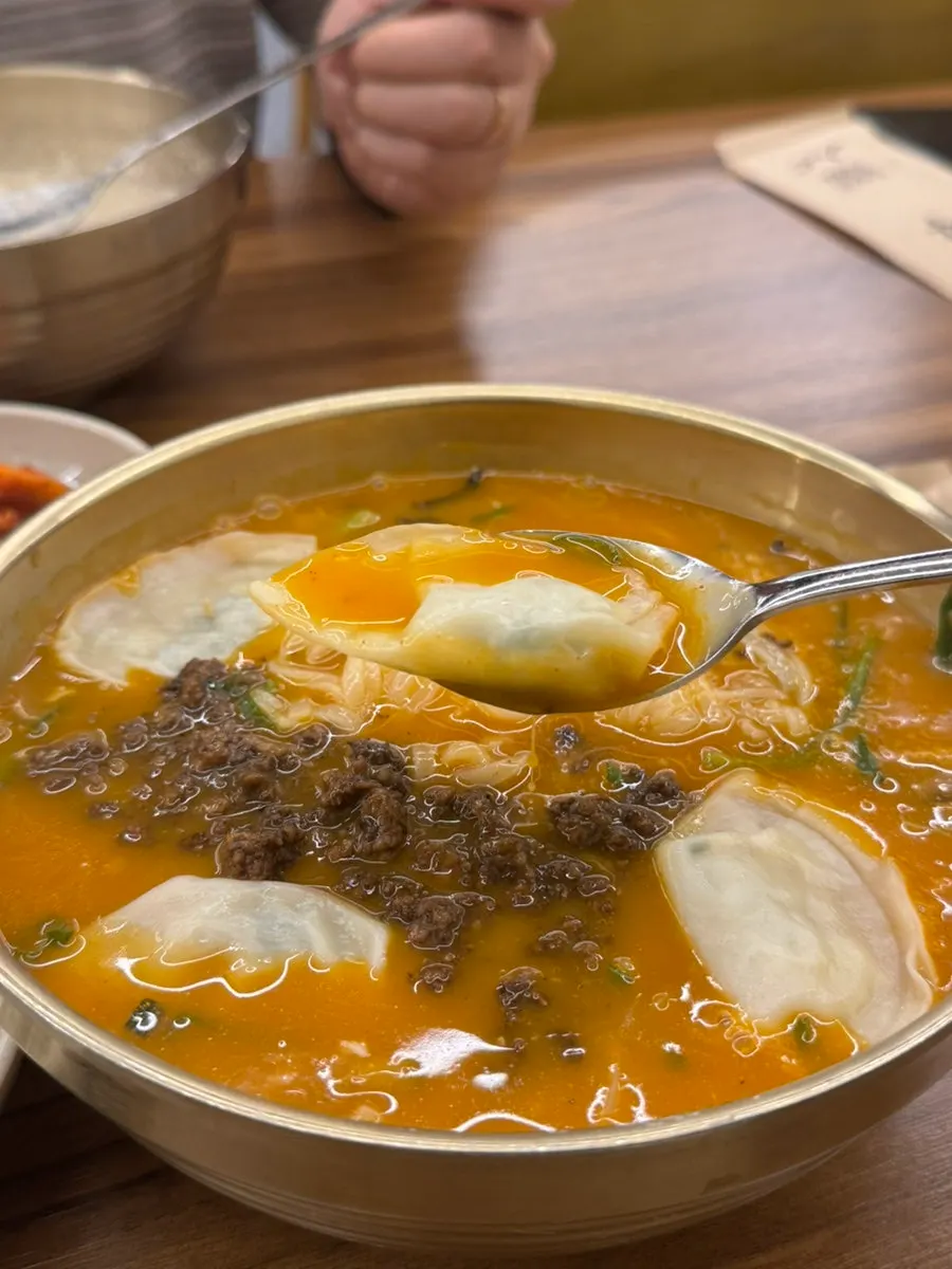 Noodles lifted up from a bowl of eolkeun kalguksu