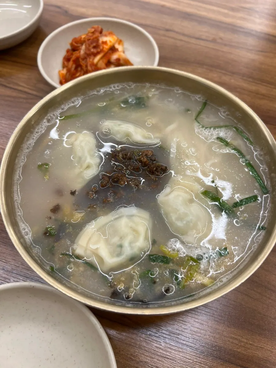 Kalguksu topped with meat garnish and dumplings