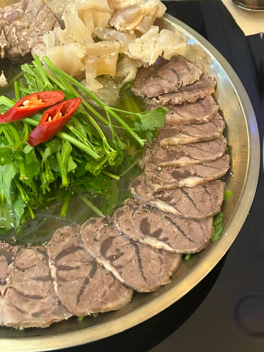 Boiled pork hot pot topped with minari and red chili