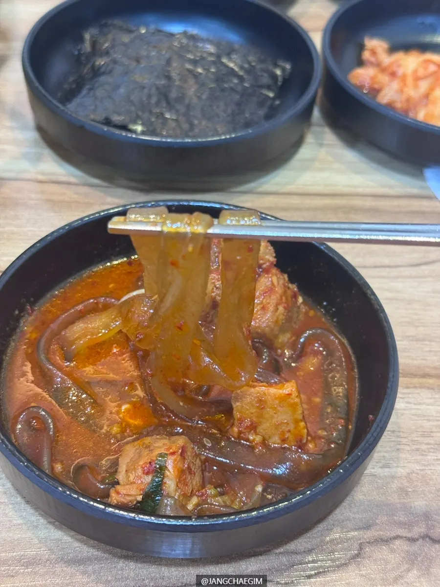 A bite of pork galbijjim topped with bean sprouts