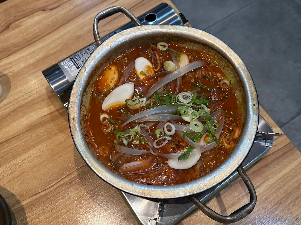 Spicy galbijjim topped with chili peppers and green onion, before boiling