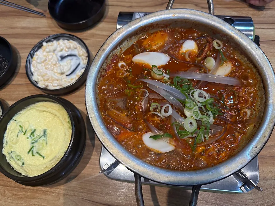 Table full with spicy galbijjim and egg custard side by side