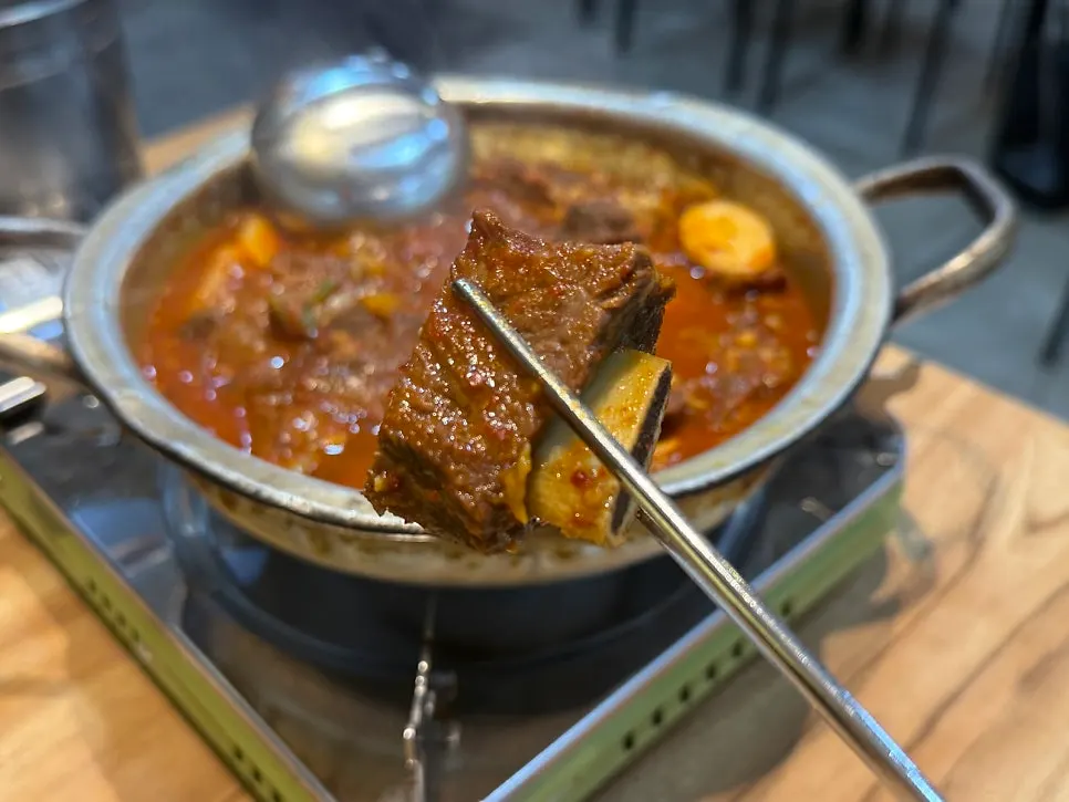 A large chunk of rib lifted out of the pot