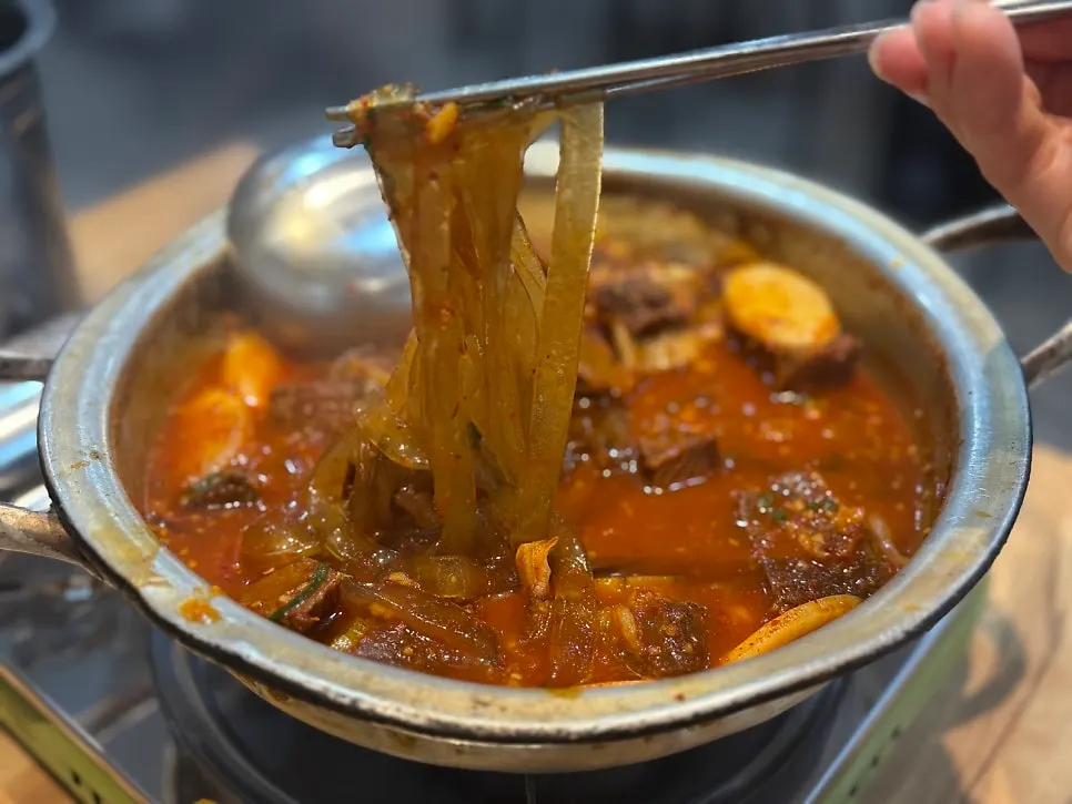 Flat noodles lifted with chopsticks