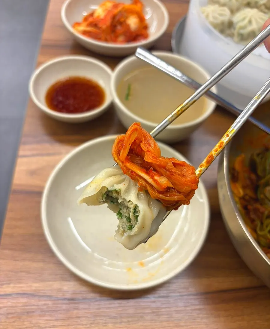 Wrapping a gyoza dumpling with kimchi on top