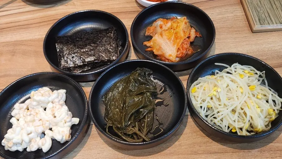 Side dish spread with seaweed, kimchi, and pickled perilla leaves