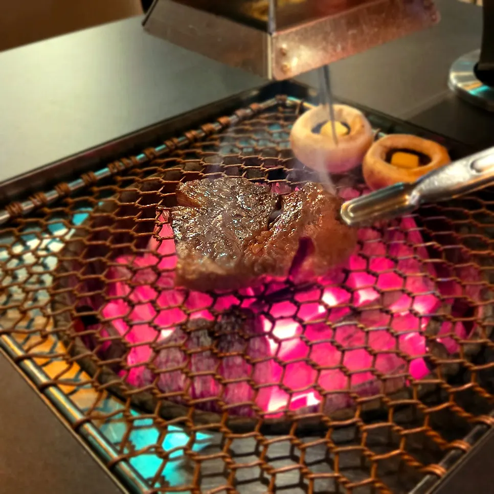 Staff grilling the meat on the charcoal grill