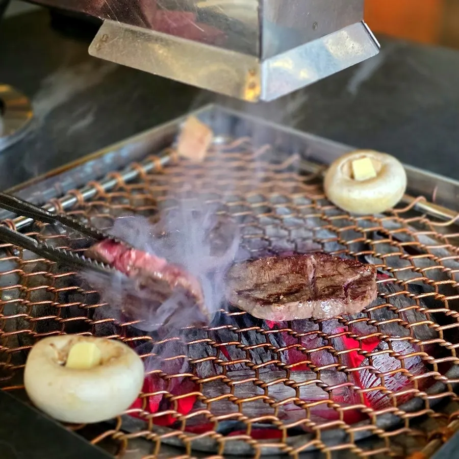 Staff grilling Seonghwa sirloin over charcoal