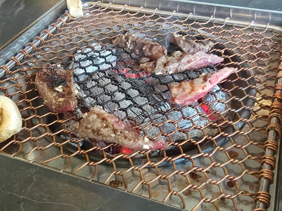 Wine-marinated short rib grilling over charcoal