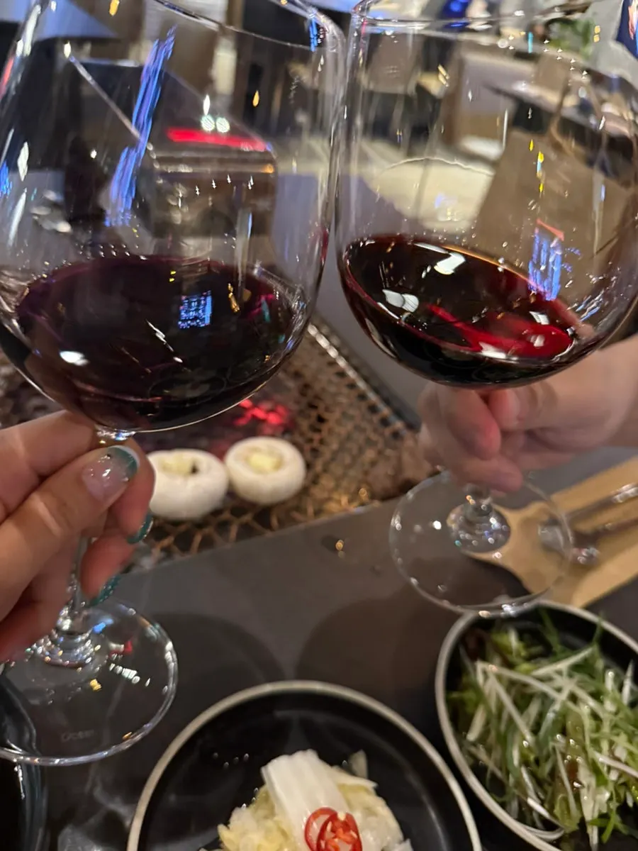 A glass of red wine poured alongside the beef