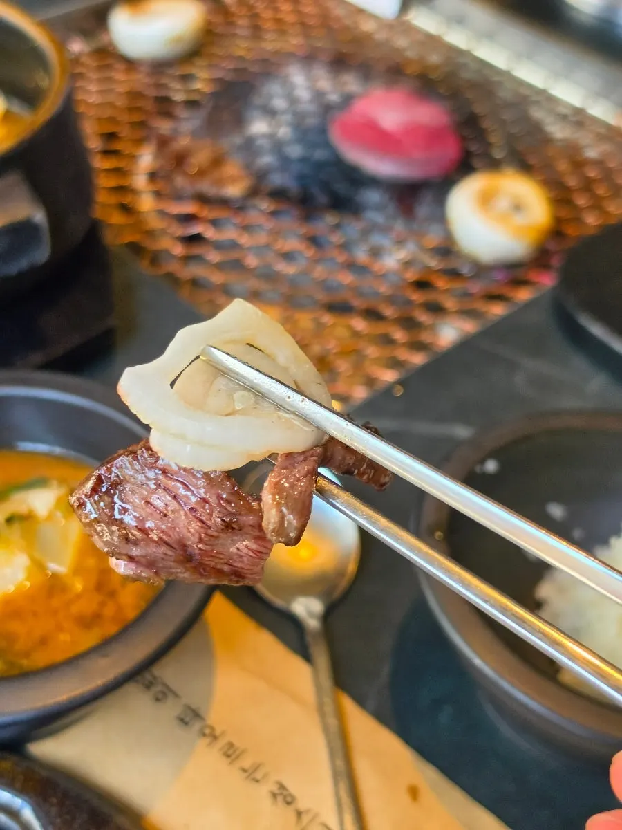 A piece of grilled Seonghwa sirloin picked up with chopsticks