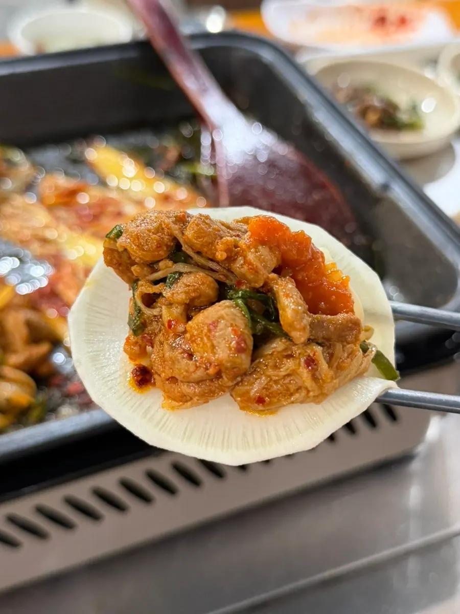 집게로 집어 올린 오리주물럭 한 점