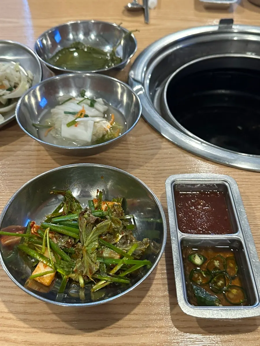 Table spread with cabbage salad, white kimchi, and other basic side dishes