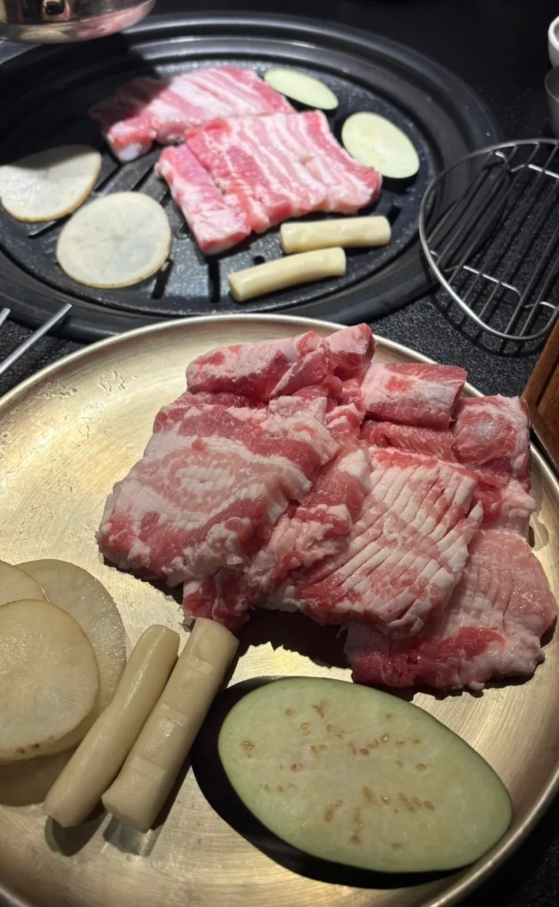 Plate of raw ribs with potato slices, eggplant, and rice cake