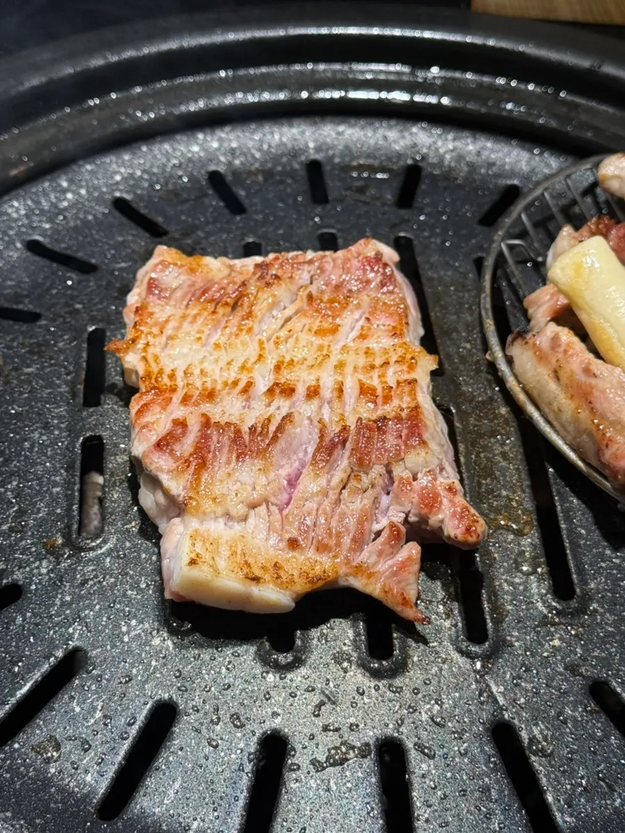 Scored raw ribs grilling to a golden brown