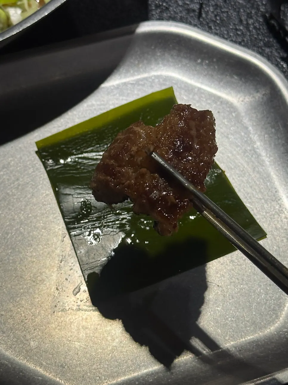 다시마쌈에 씨앗젓갈 올린 돼지갈비 한 점