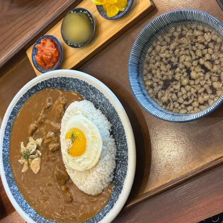 Beef curry topped with garlic flakes and a soft-boiled fried egg