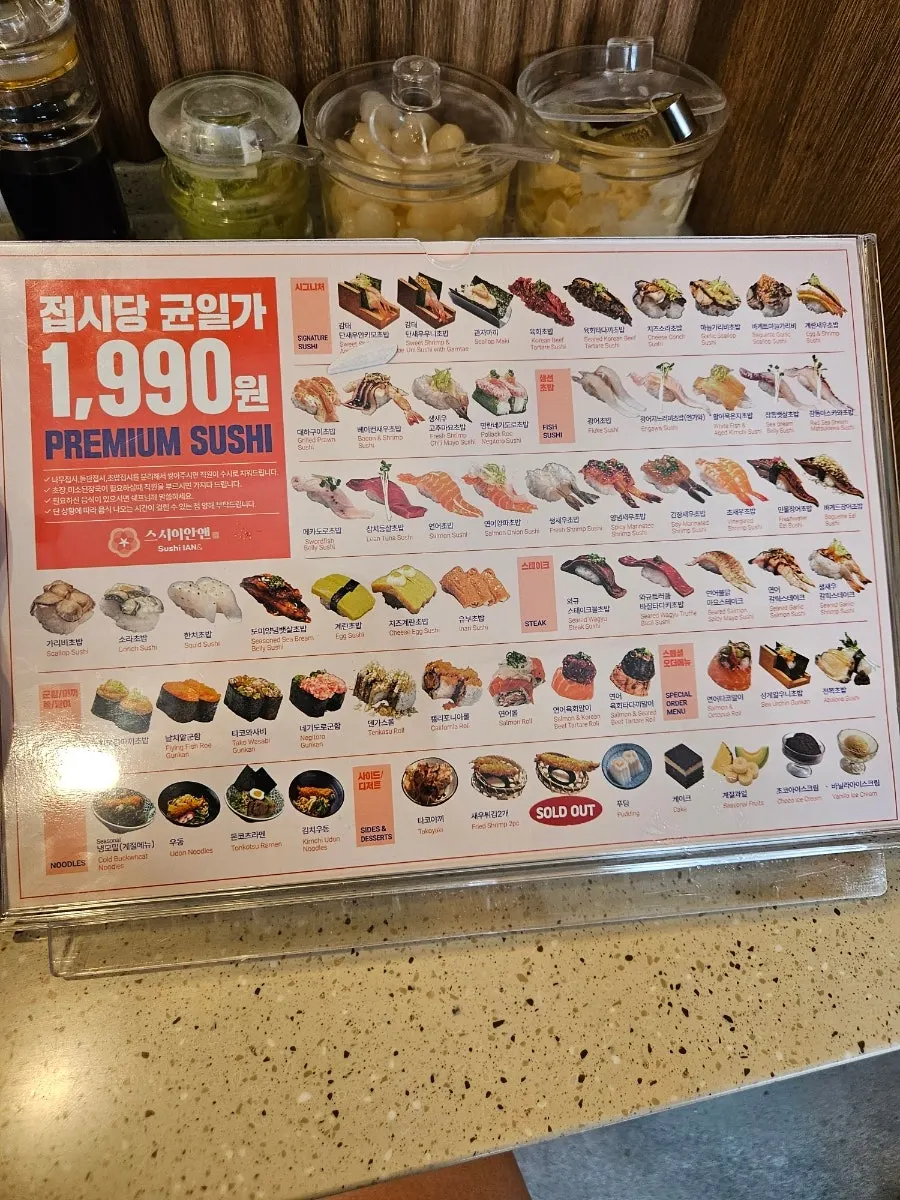 Menu board listing udon, ramen and drinks
