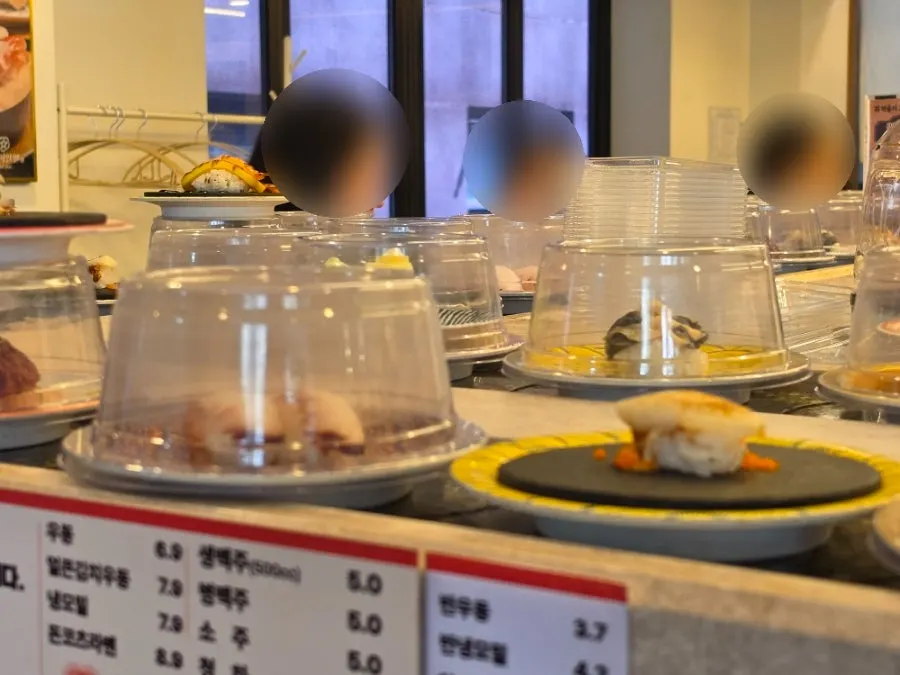 Signage listing popular sushi menu items