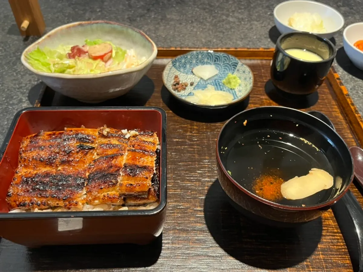 Donburi con la tapa abierta mostrando la anguila asada